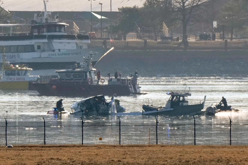 Rescue teams search icy water with plane parts showing.