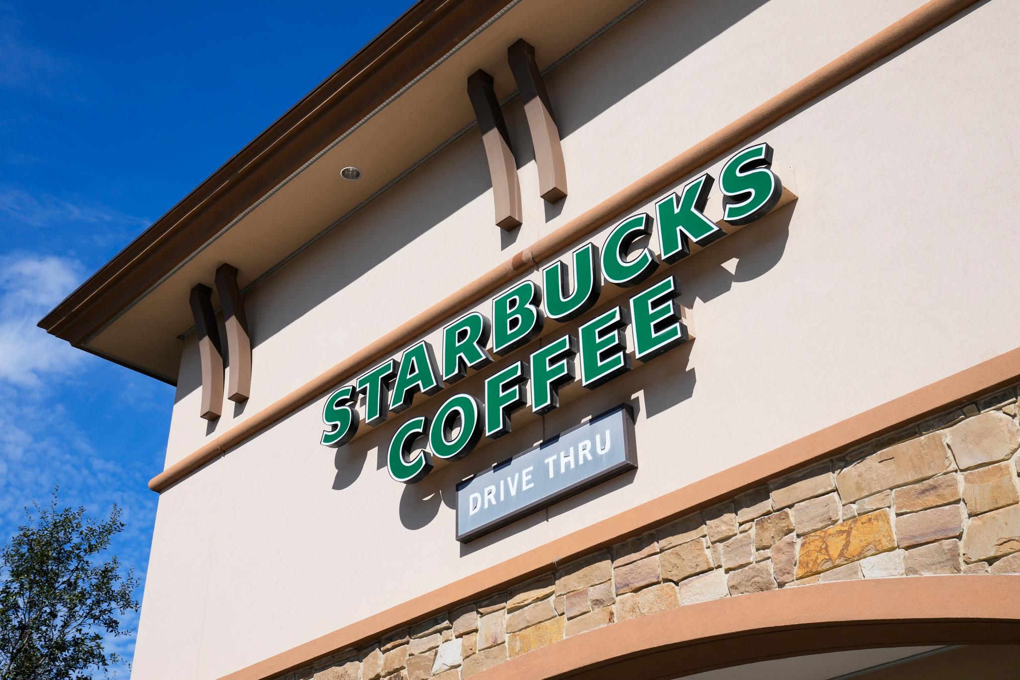 A green starbucks coffee drive thru sign on a building