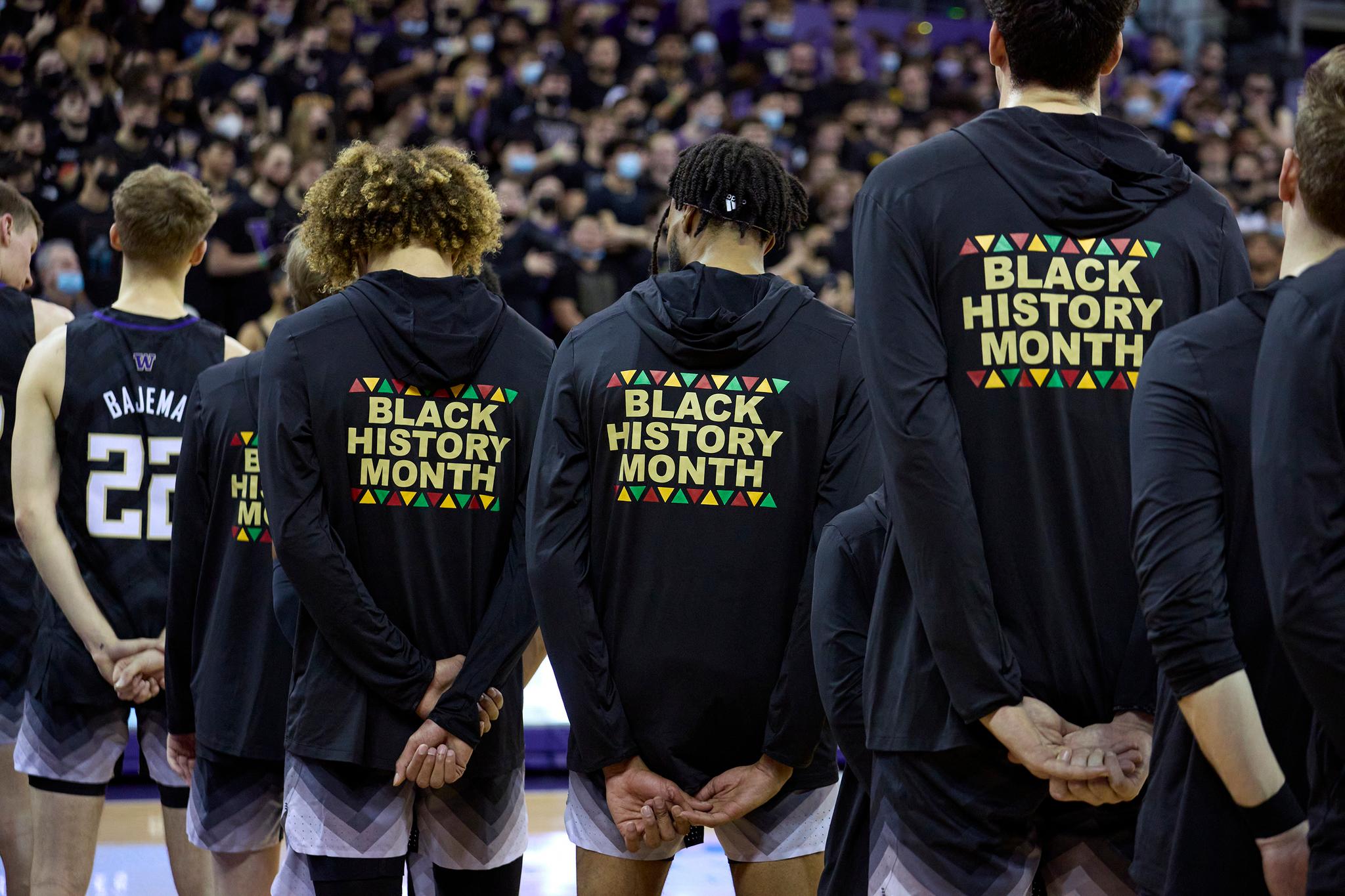 Basketball players wearing hoodies that say "Black History Month"