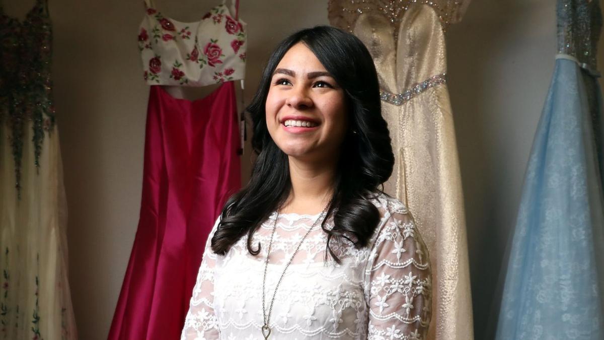 Carmen Lidia Fajardo posing with some of the dresses in the Fairy Godmother Boutique. 