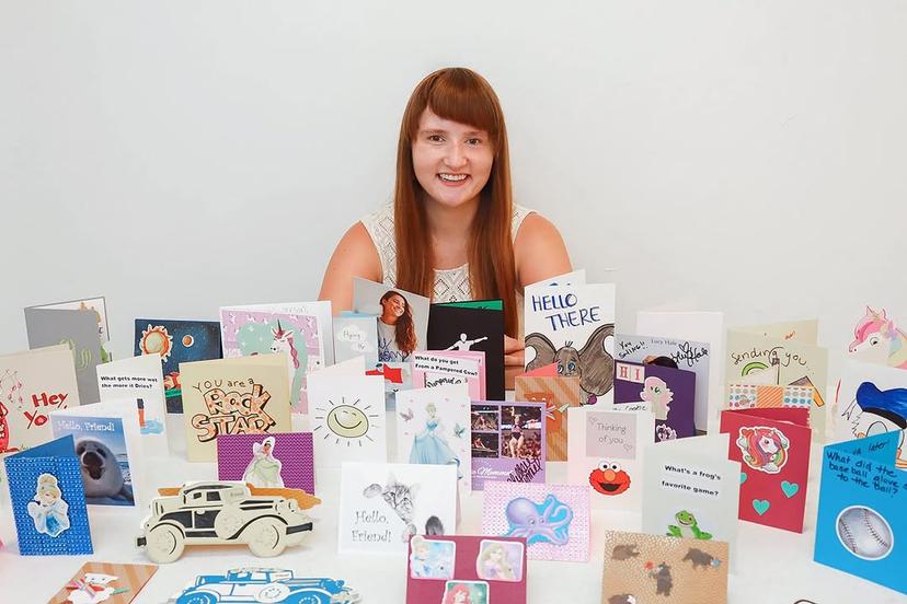 Jen Rubino posing with various cards made by people all over the country. 