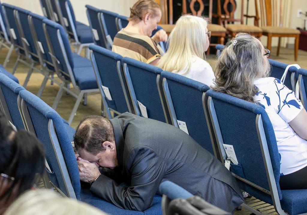 Man kneels in prayer at the Centro Cristiano El Pan de Vida, a mid-size Church of God of Prophecy congregation, in Kissimmee, Fla.