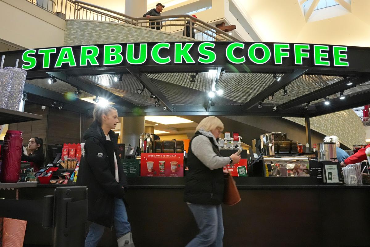 People walking in front of a Starbucks kiosk