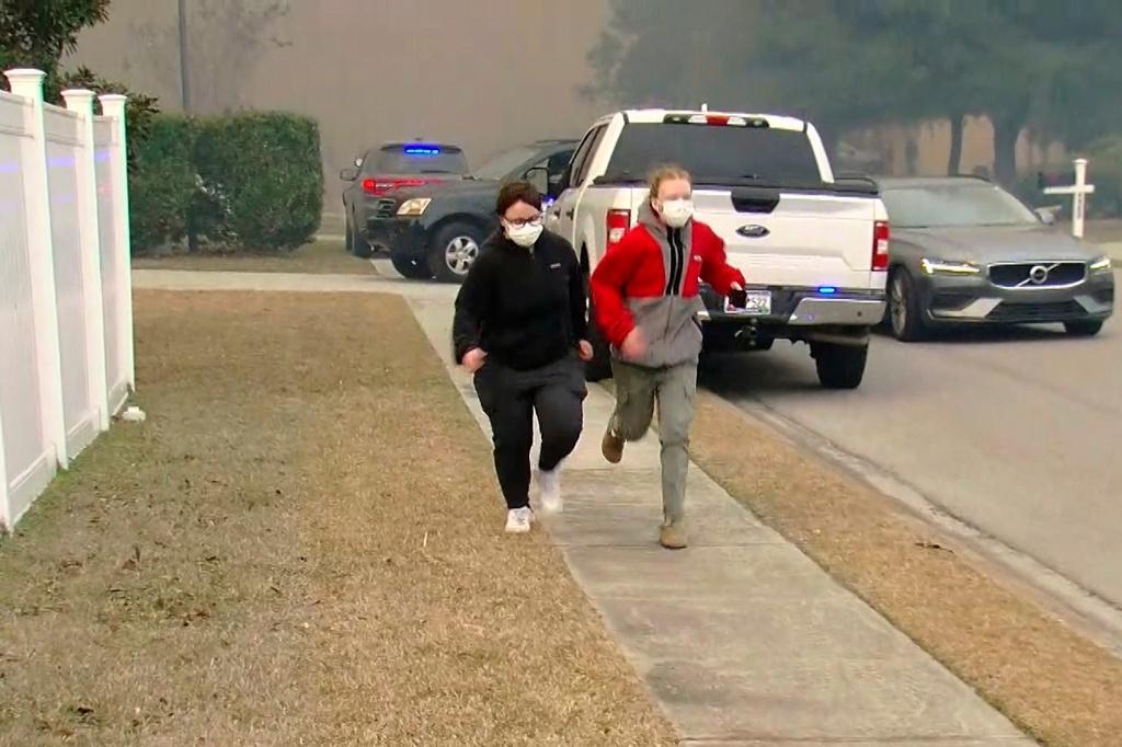 People move from an area where crews work to contain a fire in the Carolina Forest area west of the coastal resort city of Myrtle Beach, S.C.