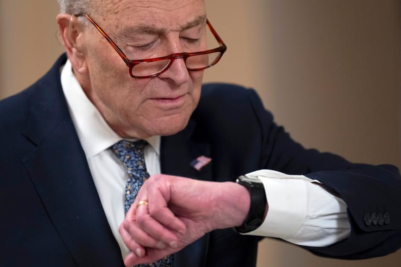 Man with glasses looking at watch