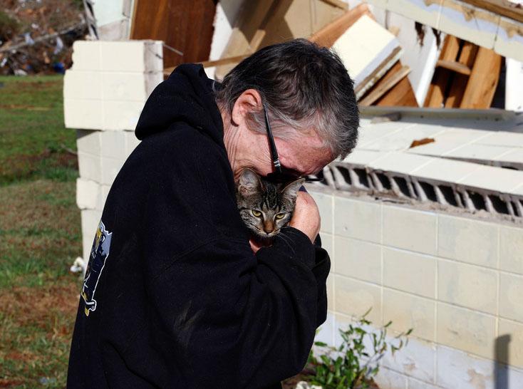 Emily Robertson reunites with one of her cats as she looks for personal belongings in the damage after a tornado passed through where two people lost their lives in Plantersville, Ala. 