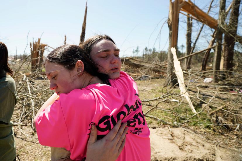 Hailey Hart, 21, right, hugs a friend, Sage Falgoust, 16, after recalling how she, her fiance and their dogs rode out Saturday's tornado in their 1994 in Tylertown, Miss.