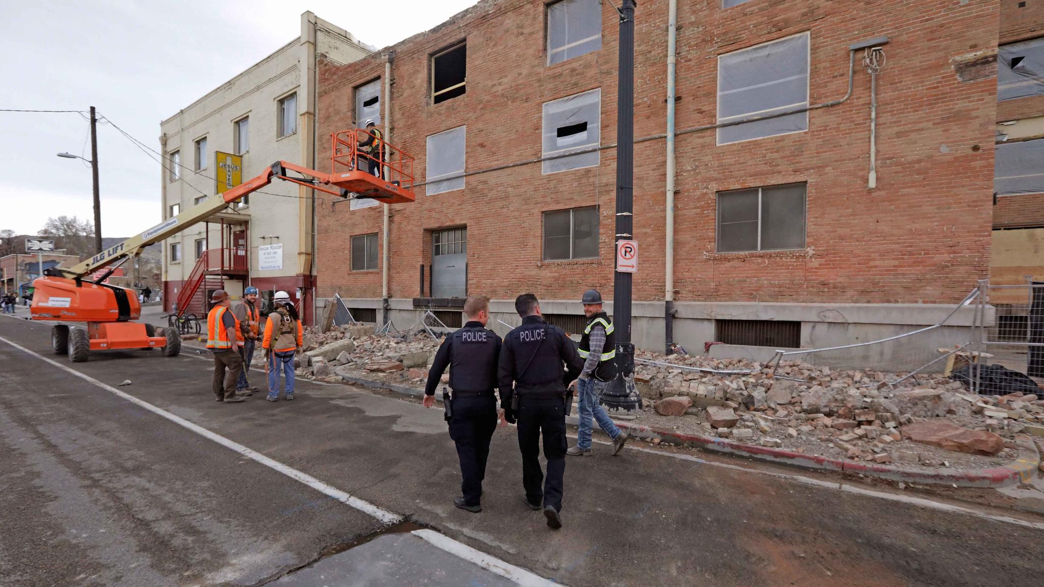 Police officers walk pass rubble after an earthquake in Salt Lake City