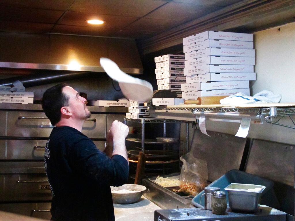 tosses pizza