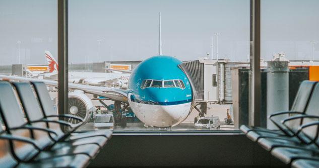 Turquoise airplane in window of airport