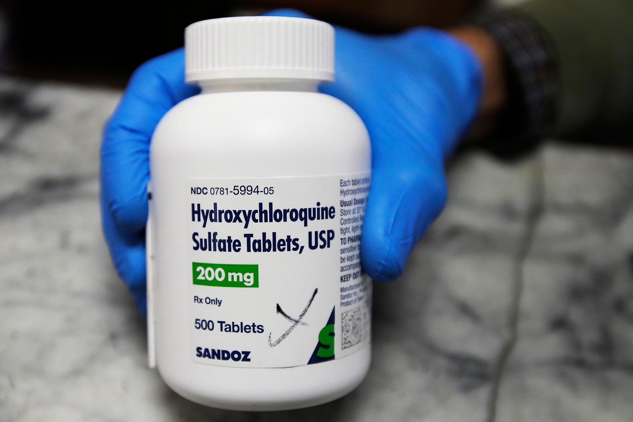Person holding a bottle of hydroxychloroquine