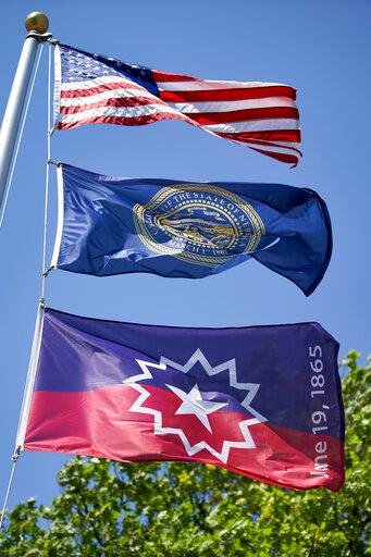 The Juneteenth flag, bottom, flies beneath the U.S. flag and the State of Nebraska flag in Omaha