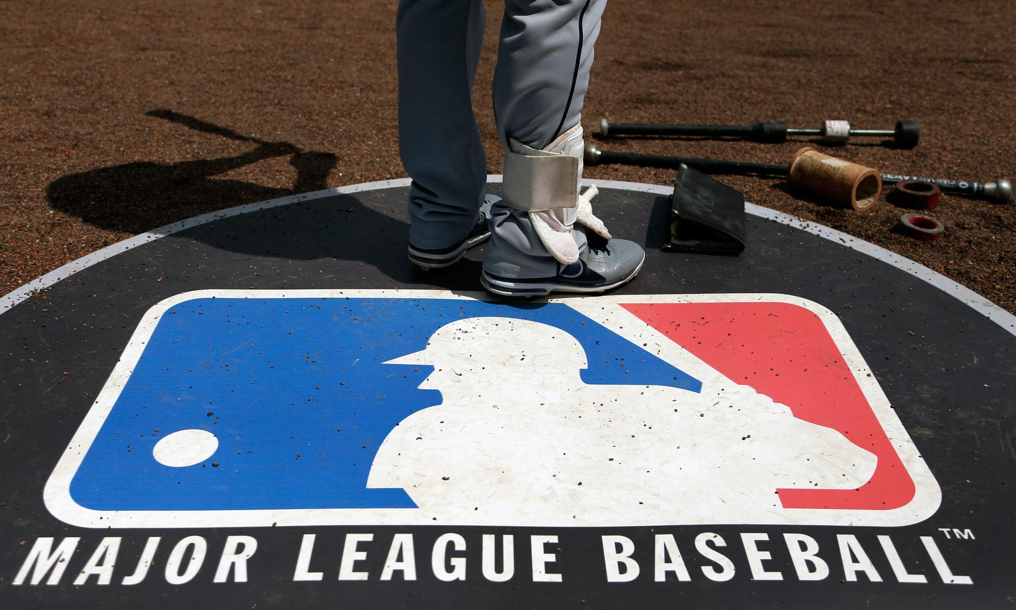 player standing near Major League Baseball logo