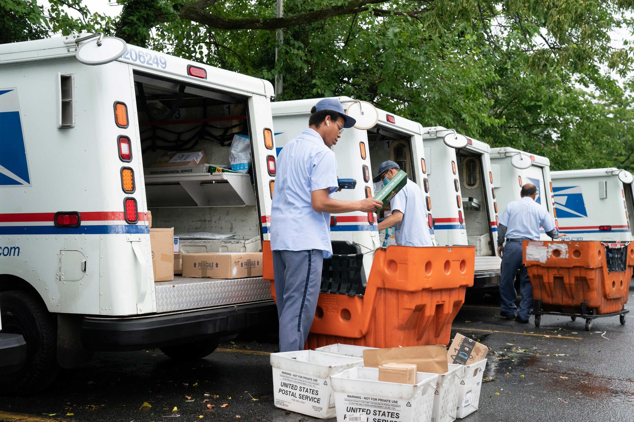 letter carriers load mail trucks