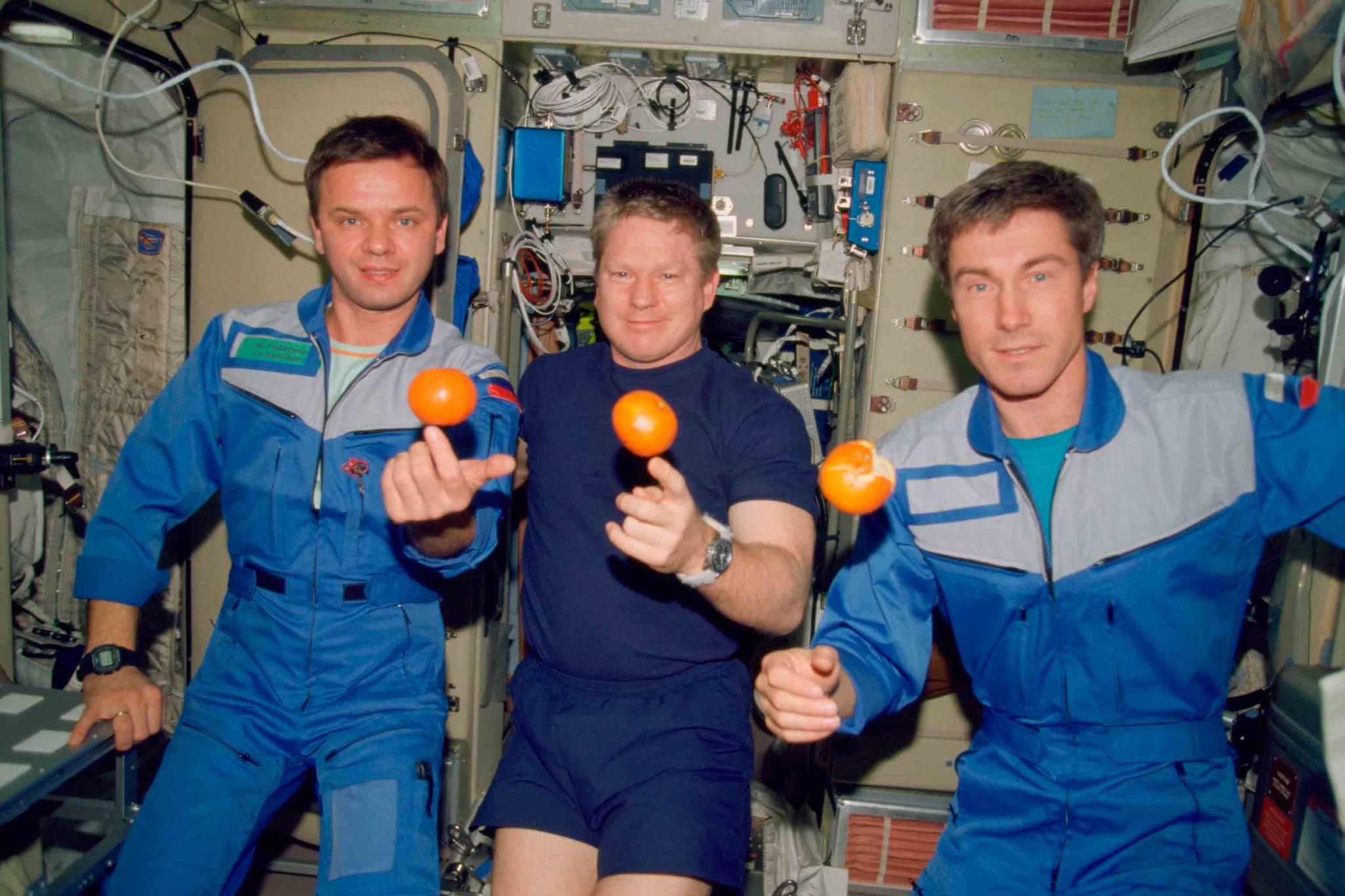 In this photo provided by NASA, the Expedition 1 crew members pose with fresh oranges onboard the Zvezda Service Module of the Earth-orbiting International Space Station on Dec. 4, 2000.