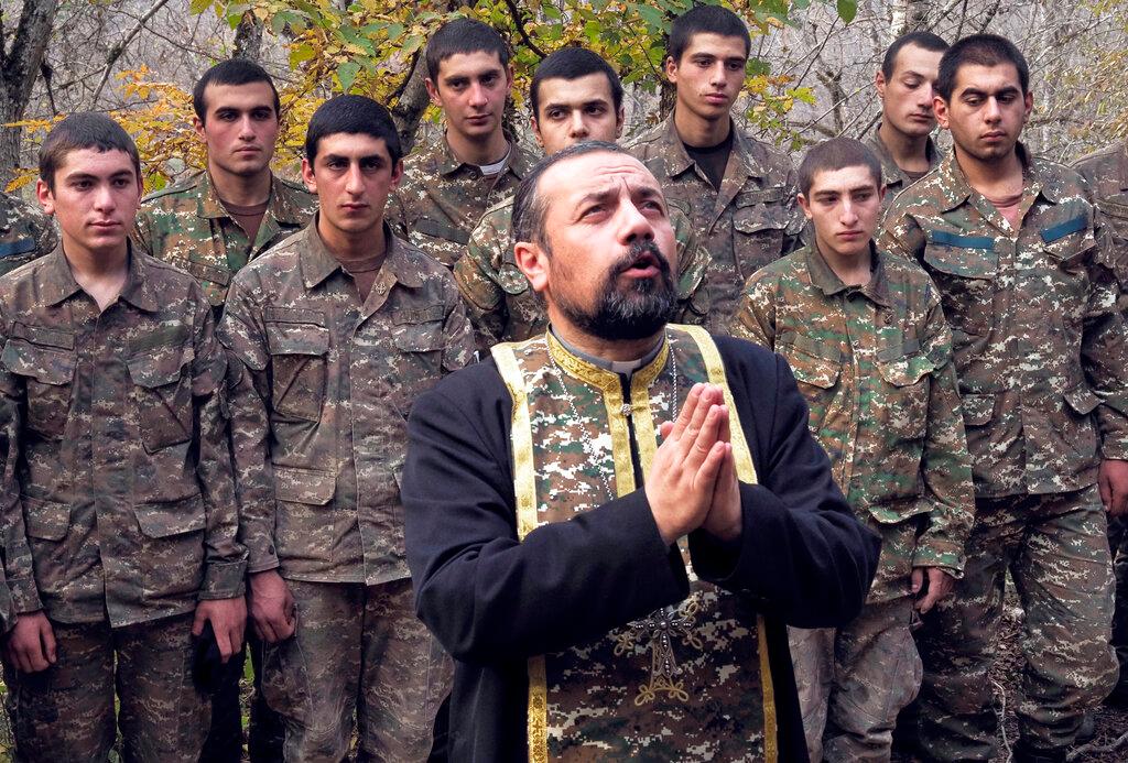 Priest Sebeos Galachyan conducts a baptism ceremony for ethnic Armenian soldiers in a military camp near the front line