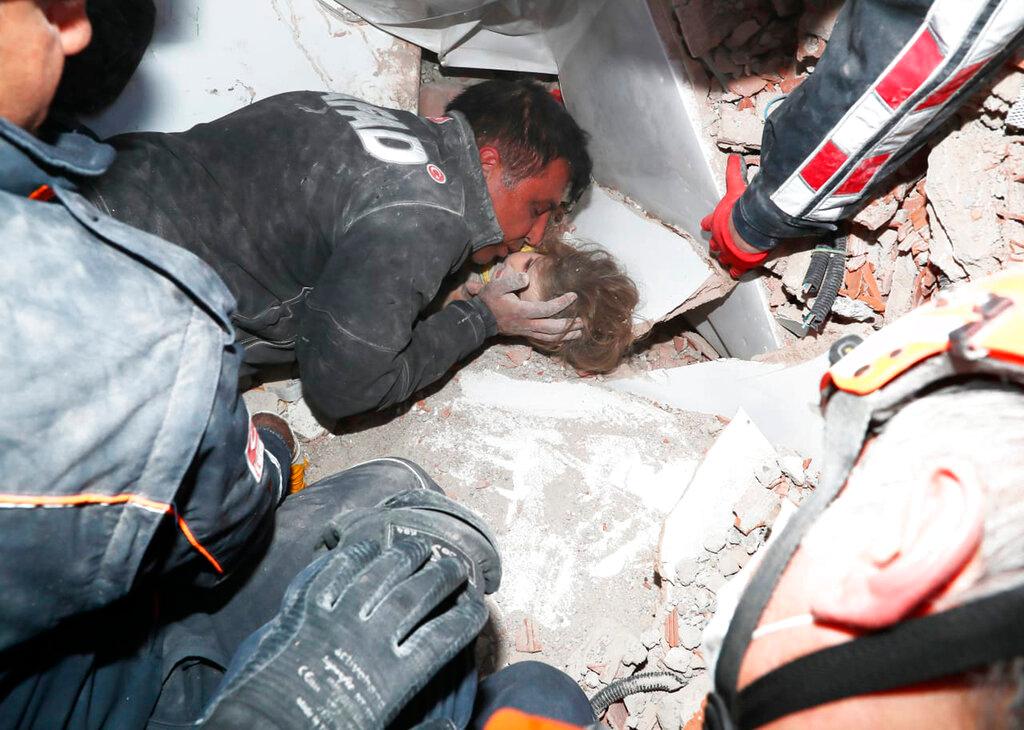 Stunned rescue workers comfort child found in debris