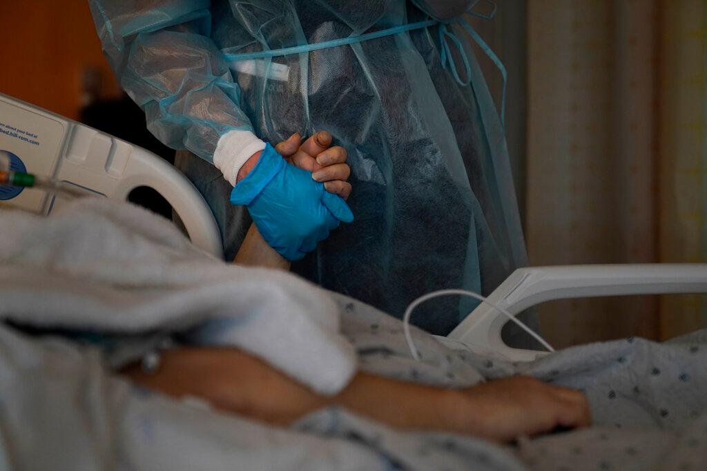 Hospital Chaplain holding patient's hand 