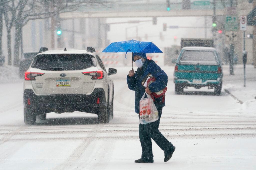 Man crosses snow covered street 