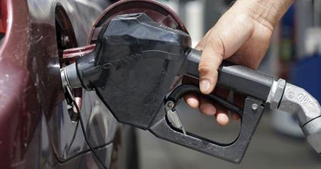 Person holding gas pump nozzle pumping gas