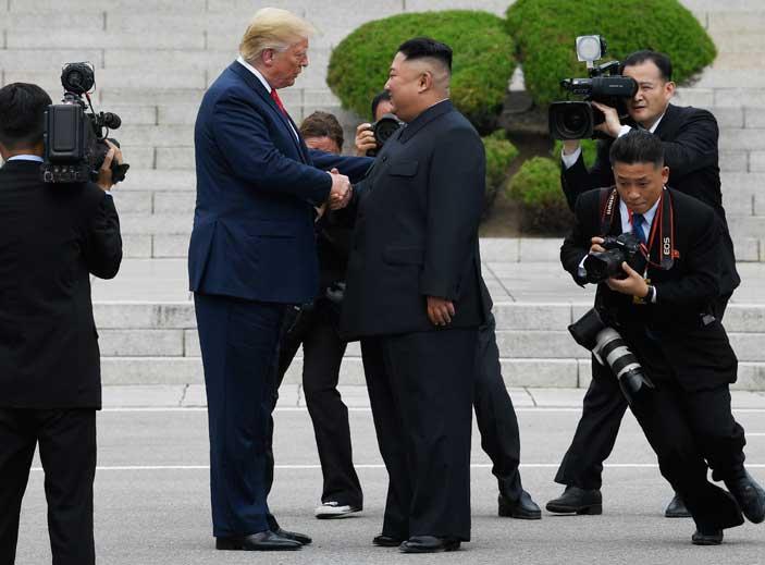 Trump and Kim smile, shake hands in North Korea DMZ