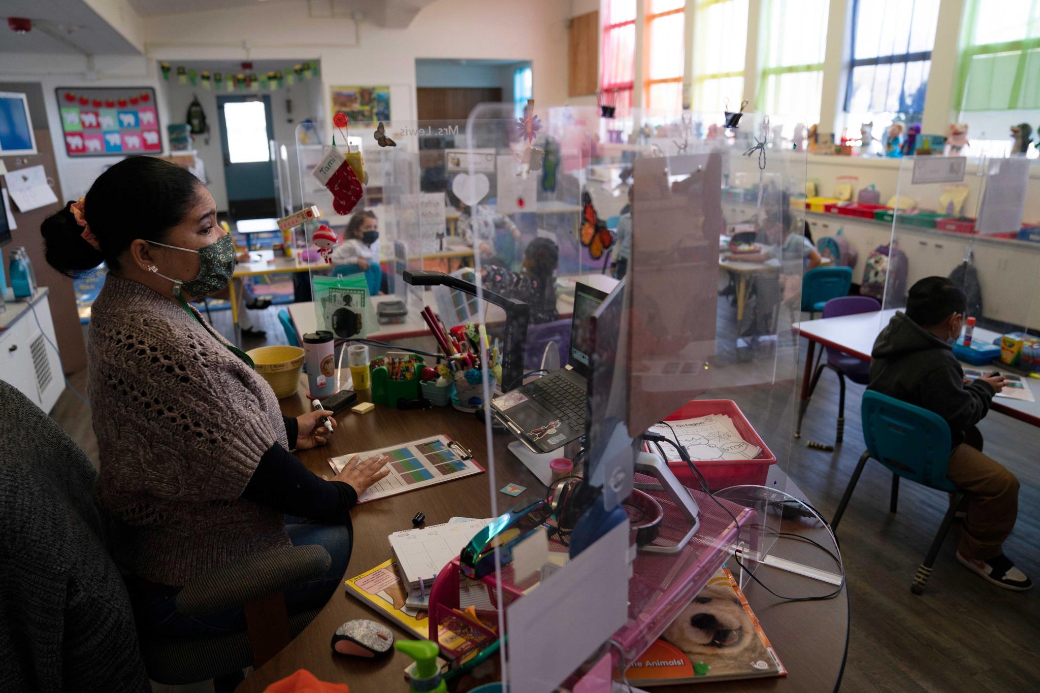 teacher teaches her class surrounded by protective shields