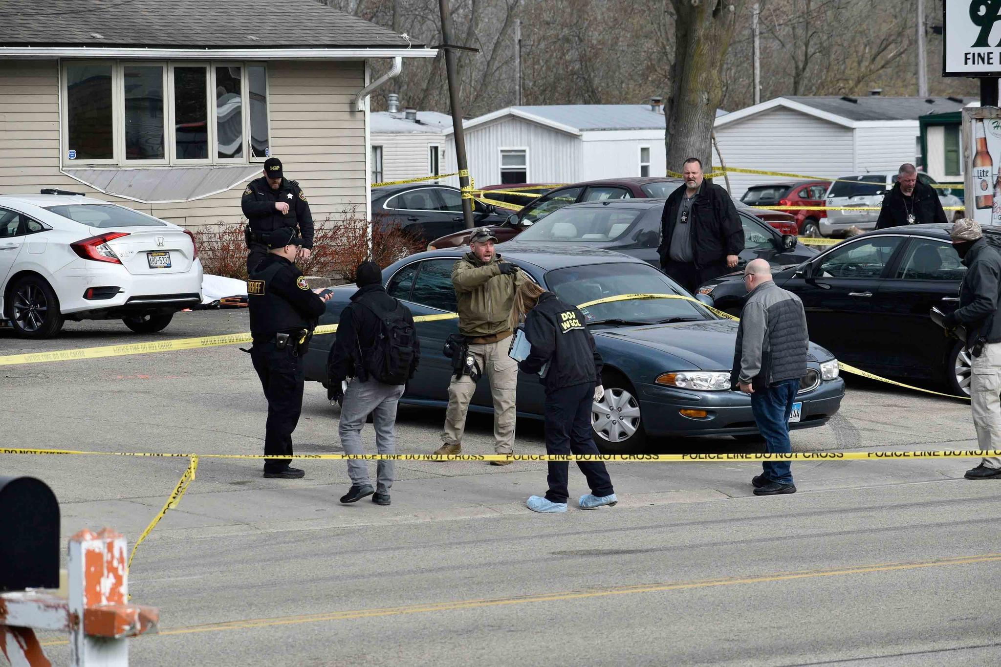 Investigators confer during an investigation outside the Somers House Tavern, in Kenosha, Wis.