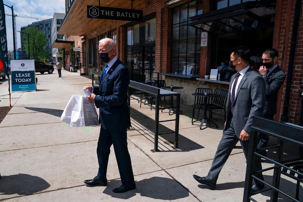 President Joe Biden carries a food order out of Taqueria Las Gemelas restaurant in D.C.