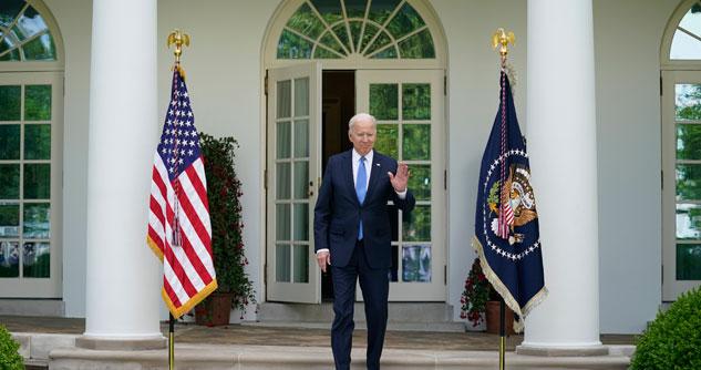 President Biden with hand up to wave coming out of the White House