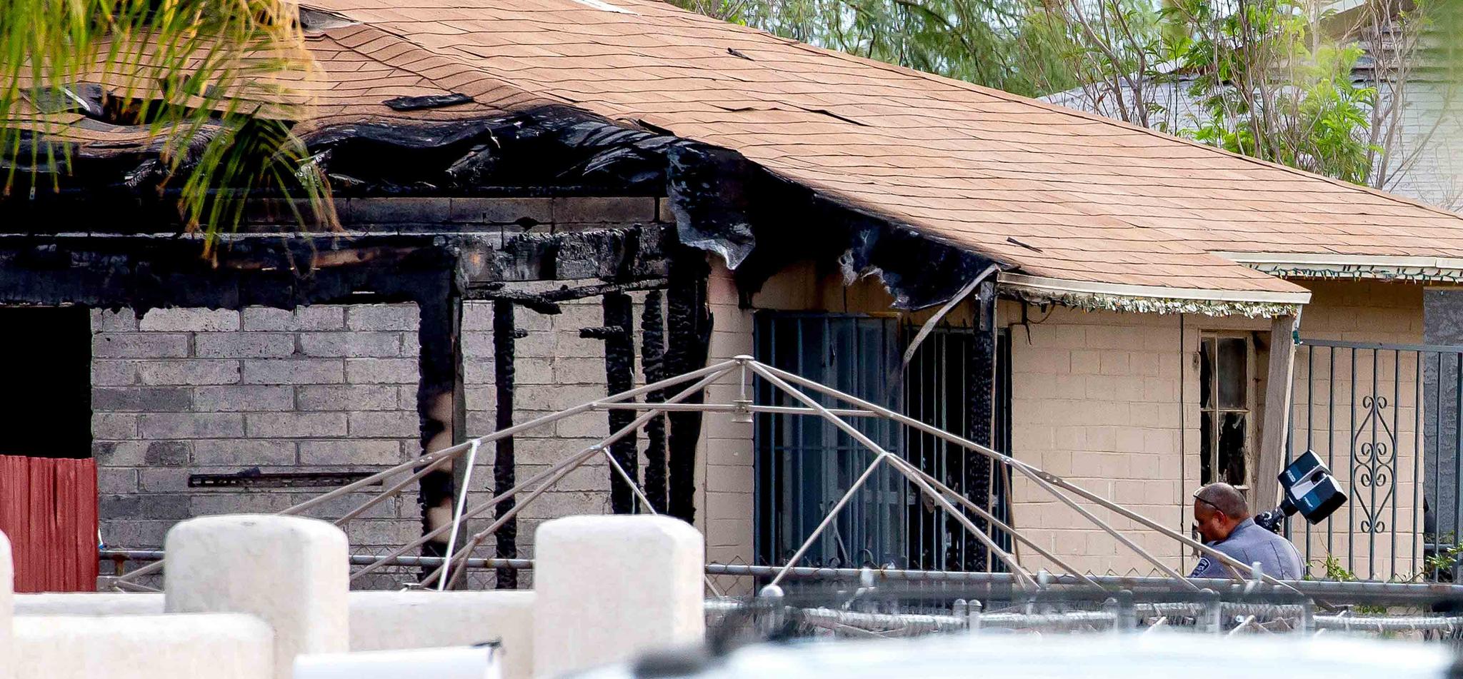 Tucson Police investigators work at the scene of a house fire where a body was found in Tucson, Ariz., Monday, July 19, 2021.