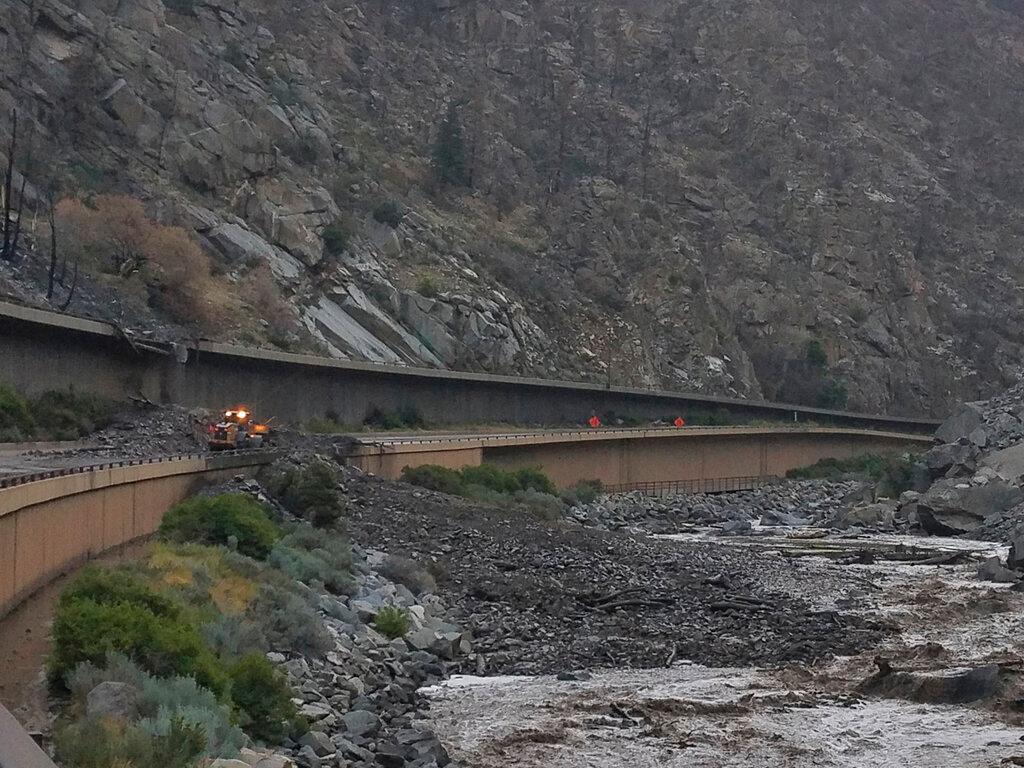 In this photo provided by the Colorado Department of Transportation, equipment works to clear mud and debris from a mudslide on Interstate-70 through Glenwood Canyon, Colo.