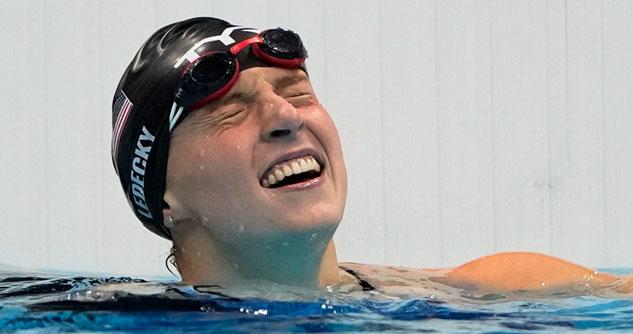 Female swimmer with her eyes shut with black swim cap on