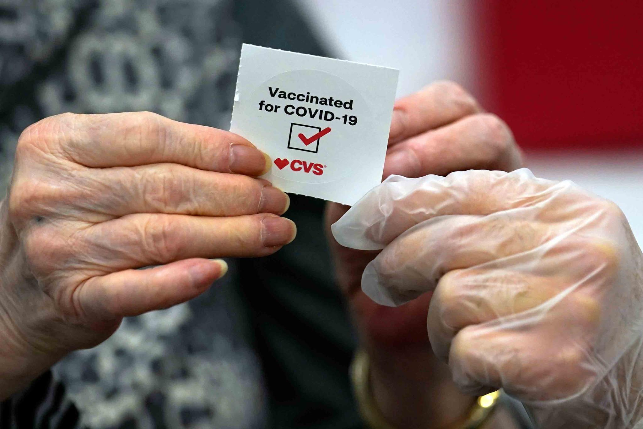 In this March 1, 2021, file photo, a patient receives a sticker after receiving a shot of the Moderna COVID-19 at a CVS Pharmacy branch in Los Angeles.