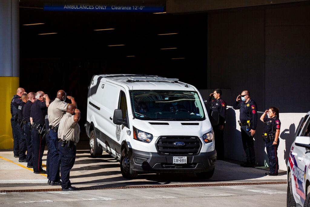 Harris County Medical Examiner van exits the Memorial Hermann Hospital transporting a Harris County Pct. 4 deputy who was shot and killed to the Harris County Institute of Forensic Sciences, Saturday, Oct. 16, 2021, in Houston. Three constable deputies were shot in an ambush early Saturday morning while working an extra shift at a Houston bar. Authorities took one person into custody but were still searching for a man believed to be the shooter, Houston Police Executive Assistant Chief James Jones told reporters.