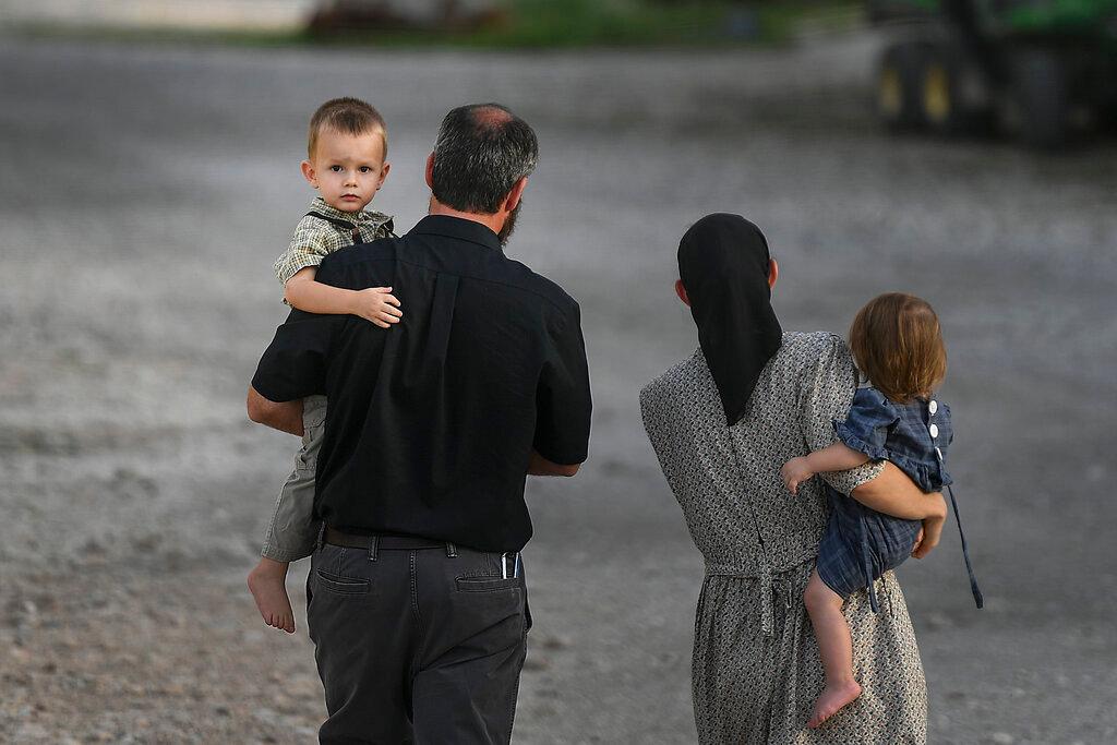 A family walks on the grounds of the Christian Aid Ministries headquarters in Titanyen, Haiti.