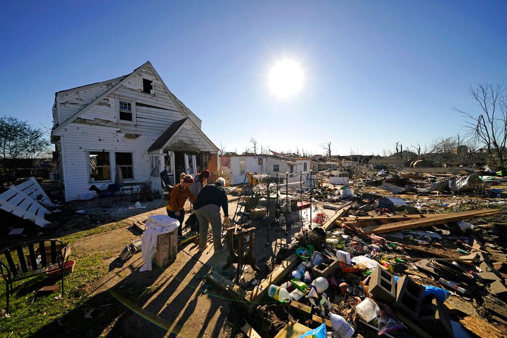 Volunteers, mostly employees from the Mayfield Consumer Products factory, help salvage possessions from the destroyed home of Martha Thomas