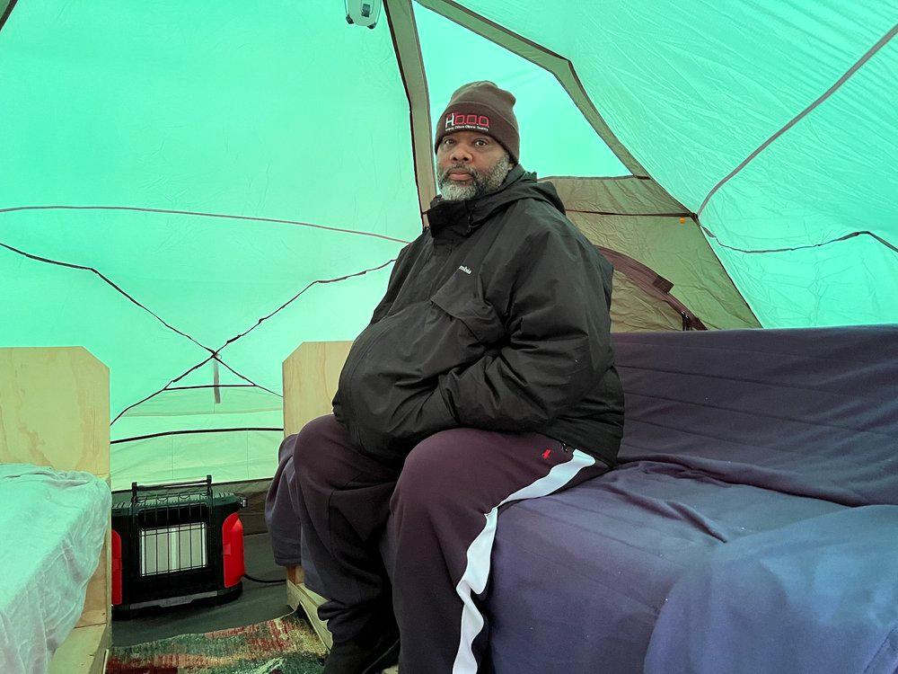 Pastor Corey Brooks sitting inside of tent