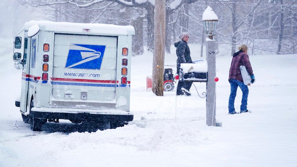 US Postal Service carrier delivers a package during a snow storm in East Derry, N.H. 