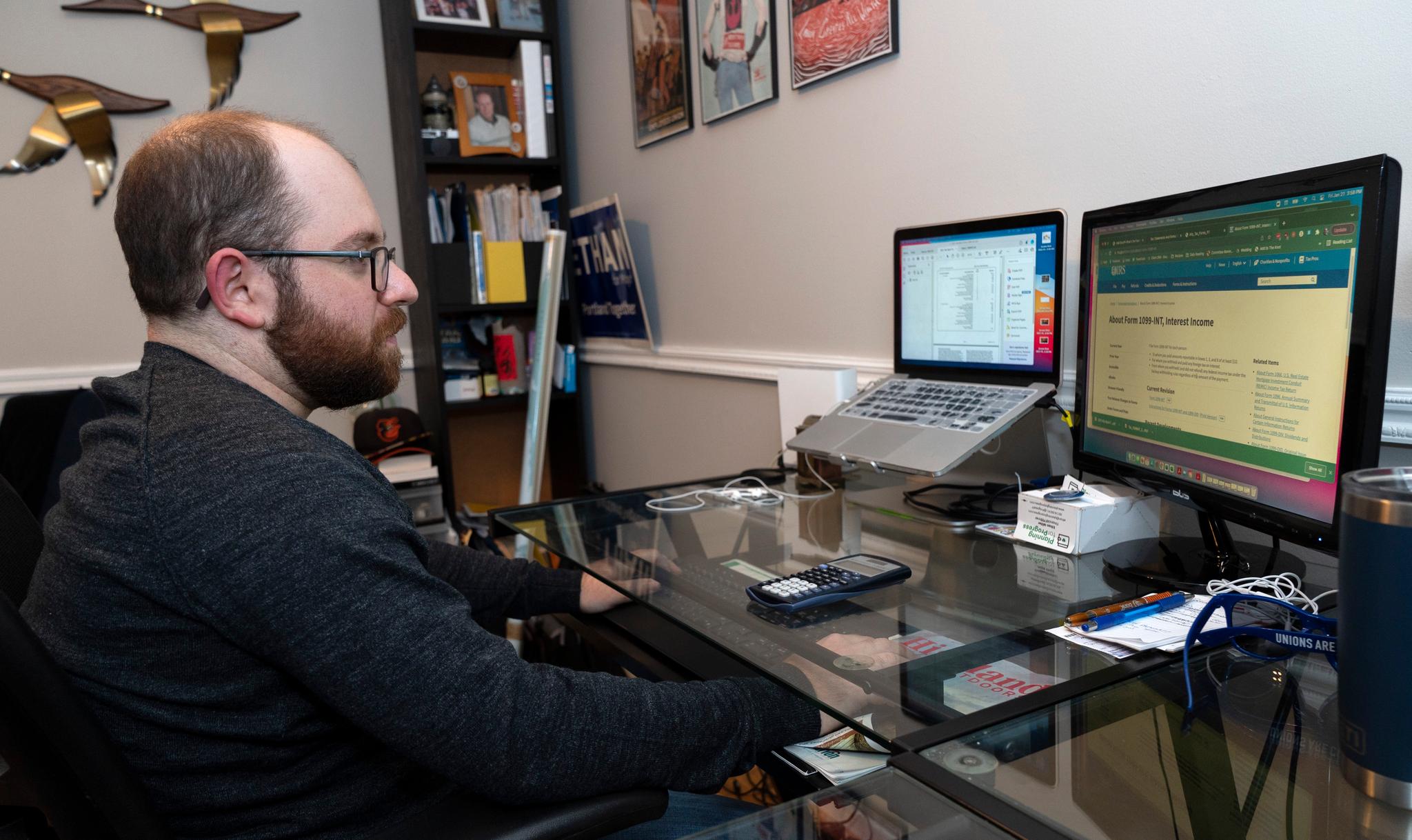 man works on his taxes at home