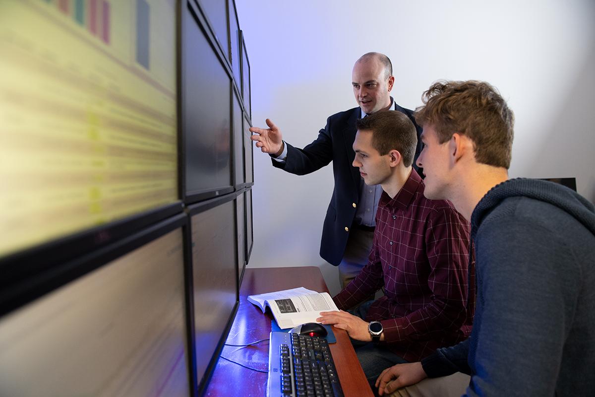 Dr. Seth Hamman, director and associate professor of cyber operations at Cedarville University, working with students in the cybersecurity computer bay.