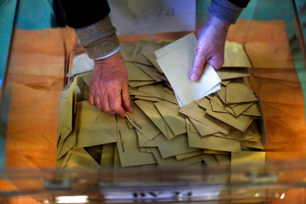 person counting paper ballots