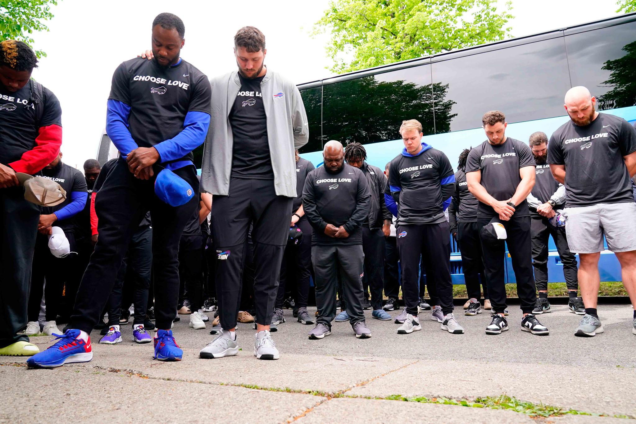 Members of the Buffalo Bills pray before visiting the scene of Saturday's shooting at a supermarket, in Buffalo, N.Y., Wednesday, May 18, 2022.