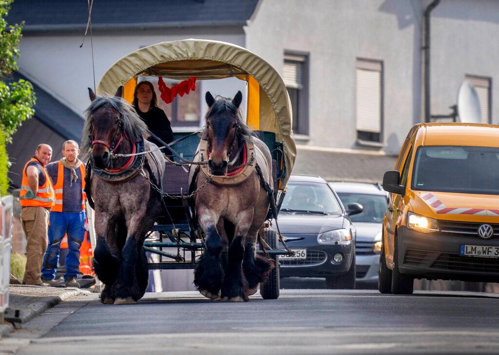 Horse farmer Stephanie Kirchner steers her coach on the main road through her hometown Schupbach near Limburg, Germany