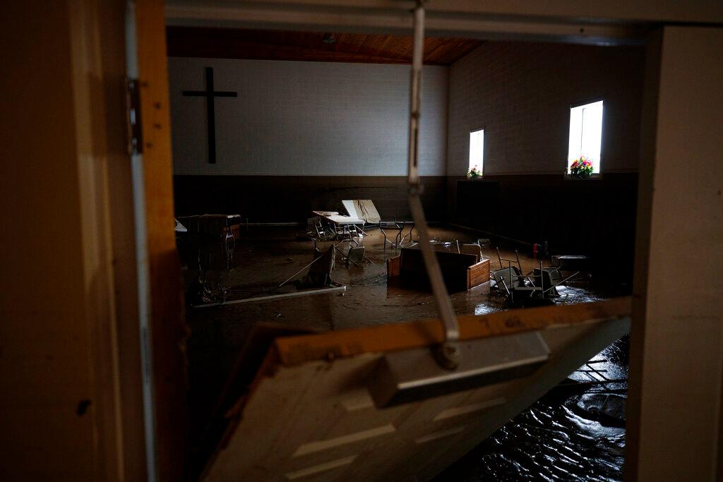 Chairs and pews sink down in mud inside Baptist Bible Church, Thursday, July 14, 2022, in Whitewood, Va.