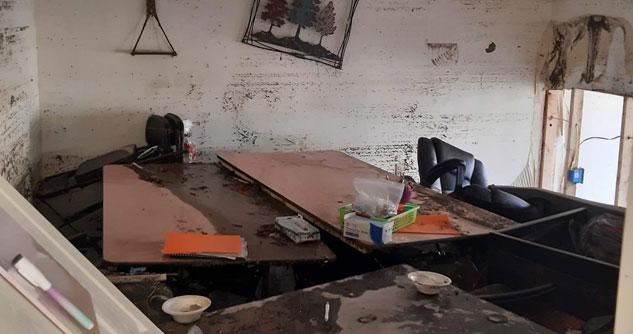 Tables piled up on each other with mud marks on the walls