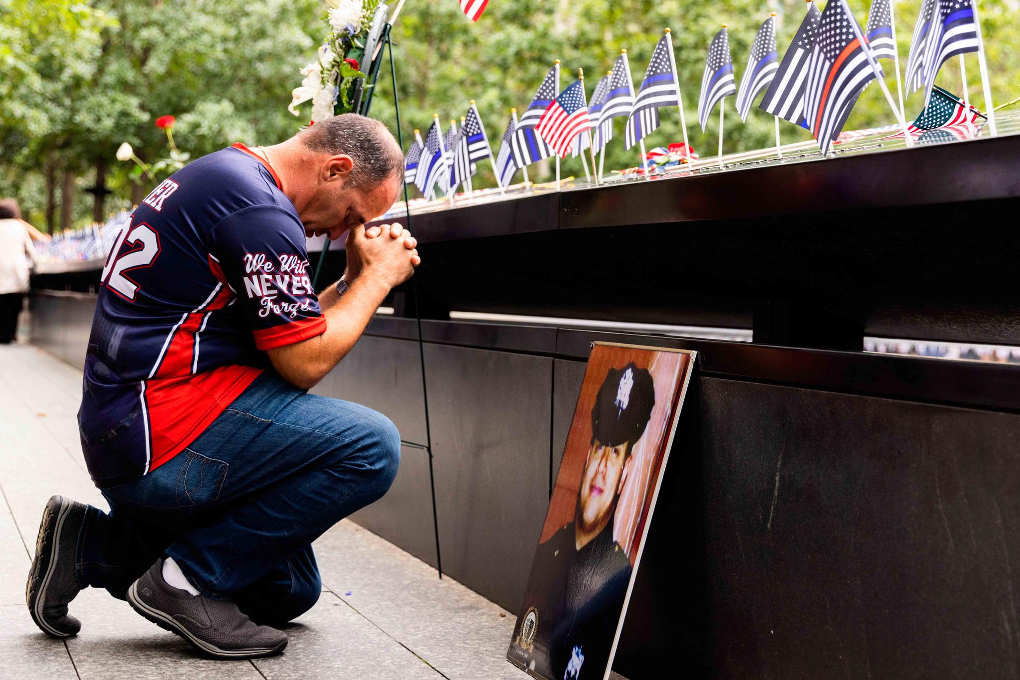 A man prays at the south pool during a ceremony to commemorate the 21st anniversary of the Sept. 11 attacks, Sunday, Sept. 11, 2022, at the National September 11 Memorial & Museum in New York.