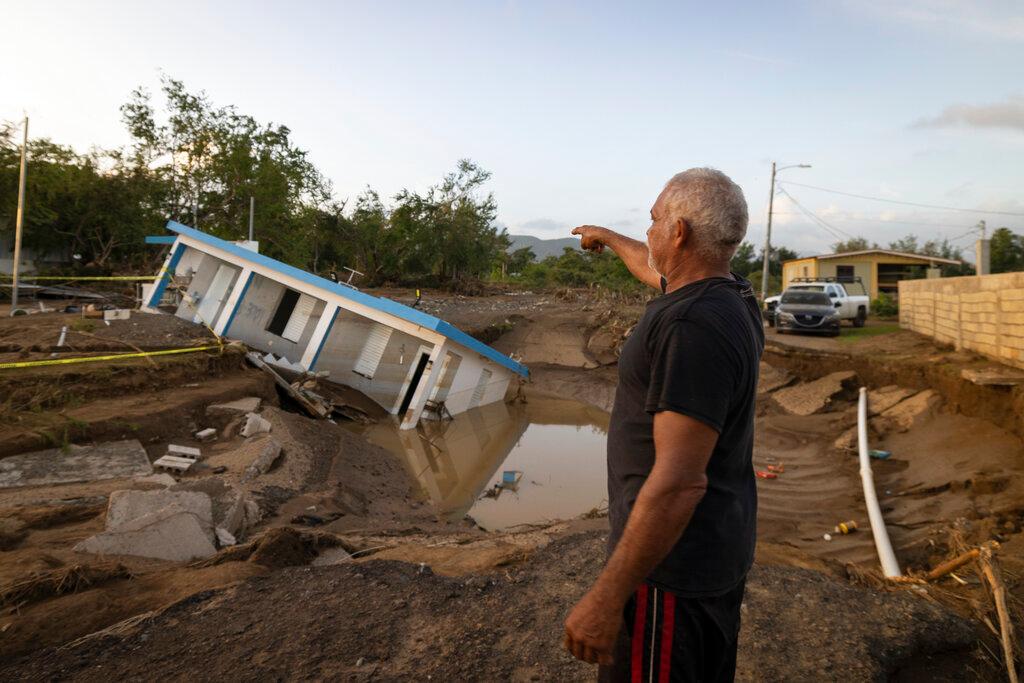 A man points to a home that was collapsed by Hurricane Fiona at Villa Esperanza in Salinas, Puerto Rico