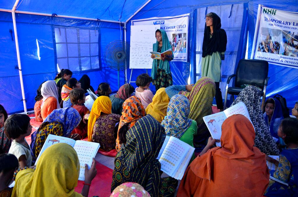 Image of students and teachers in make shift classroom