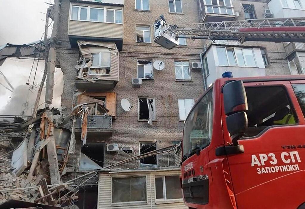 Rescuers work on a scene of building damaged by shelling in Zaporizhzhia, Ukraine