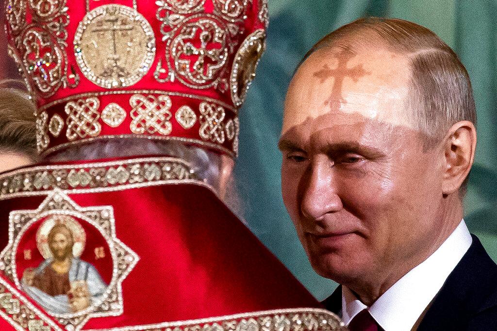 Russian Orthodox Patriarch Kirill, left, talks to President Vladimir Putin, right, during the Easter service in the Christ the Savior Cathedral in Moscow, Russia